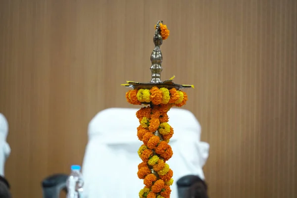 Une lampe à huile en laiton décorée de fleurs de souci jaune et orange pour la cérémonie d'éclairage de la lampe d'inauguration — Photo