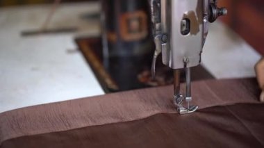 Kılavuz dikiş makinesinin kahverengi kumaş dikme görüntüsü..