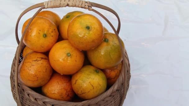Frische reife Mandarinenorangen stapeln sich im geflochtenen Korb, Wassertröpfchen lassen die Früchte frisch aussehen. Orangenfrüchte sind süß, köstlich. Platziert auf weißem Hintergrund, isoliert, im Raum. Chiang Mai Thailand.