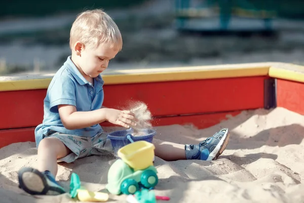 Bambino Ragazzo Sta Giocando Una Sandbox Bordo Rosso Giallo Con — Foto Stock