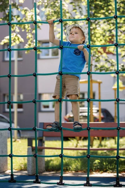 Menino Pequeno Como Uma Aranha Sobe Uma Rede Verde Cordas — Fotografia de Stock