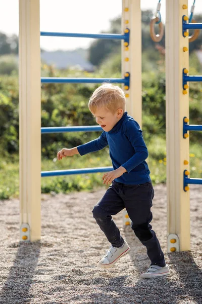 The little boy starts run forward outside on a playground on a summer day. The concept of child sport and active in fresh air.