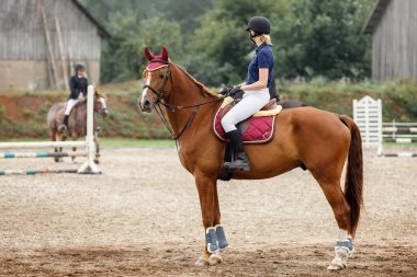 Ata binen model bir kız ve kır çiftliğinde spor binicilik atı. Binicilik sporu konsepti, binicilik atı.