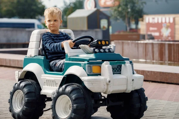 Relaxed Professional Faced Cute Little Boy Drives Large Green Toy — Stock Photo, Image