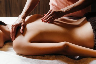 Sağlık ve rahatlama konsepti - güzel genç bir kadın yalan söylüyor ve masaj yaptırıyor.