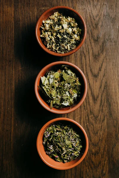 顶部的各种褐色陶瓷碗与干茶 绿茶和草药茶 — 图库照片