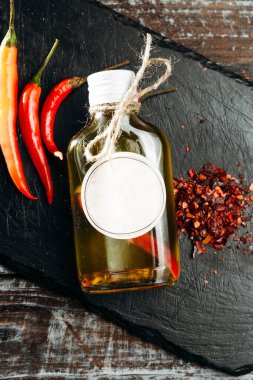 Kırmızı biberli, kırmızı biberli, cam şişede sıcak zeytinyağlı ve biberli.