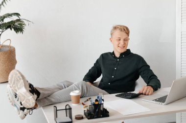 Genç, tatmin olmuş, çalışma masasında oturan, hayallere dalmış bir serbest çalışan. Bitirme işi tatmin edici iş adamı rahatlama