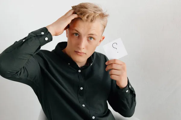 Young man in black shirt having questions at work. Intern at work