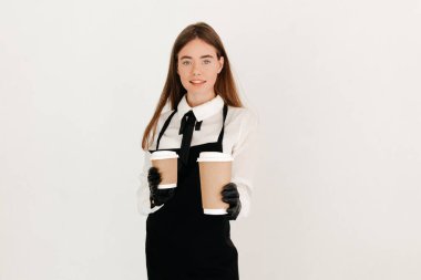 Dost canlısı garsonun portresi beyaz arka planda iki paket kahve veriyor.