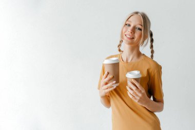 Paket kahveyle poz veren bir kız. İyi bir gün için mükemmel bir sabah içkisi.