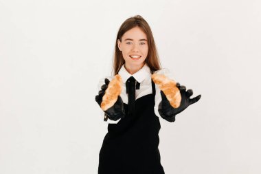 Garson bir pastanede el yapımı kruvasan satıyor.