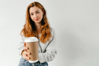 Beyaz duvar arkasında izole edilmiş, günlük kıyafetlerle gülümseyen genç bir kız, stüdyo portresi. İnsanlar yaşam tarzı kavramını hisseder