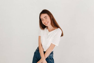 Boş bir stüdyo duvarında izole edilmiş güzel gülümseyen bir kadının stüdyo resmi.