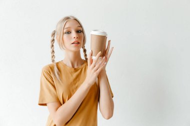 Paket kahveyle poz veren kız. Enerji ve keyif için iç.