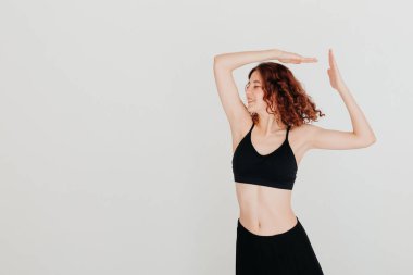 Stüdyo arka planında modern tarz dansçı pozu. Kadın jimnastik yapıyor. Spor konsepti