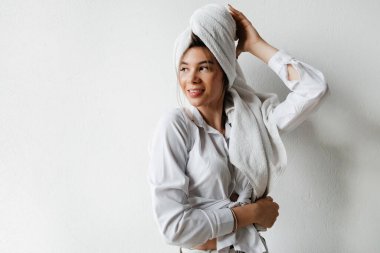 Otelde bir banyo. Beyaz gömlekli tatlı genç kız duş aldıktan sonra kafasında temiz havlu var.