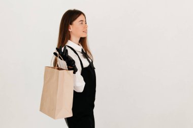 Üniformalı garsonun elinde paket yiyecek paketi var. Bir müşteriye teslim etmeye hazır.