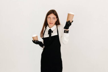Portrait of friendly waitress holding two takeaway coffees isolated on white background