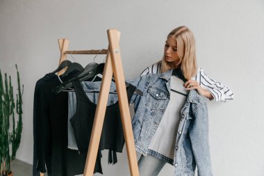 Girl thinking if she needs new clothes. Fashion, style and consumerism concept