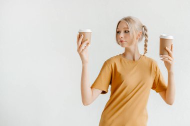 Paket kahveyle poz veren bir kız. İyi bir gün için mükemmel bir sabah içkisi.