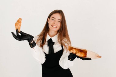 Garson kafede kruvasan paketliyor, Coronavirus sırasında müşterilerine servis yapıyor.