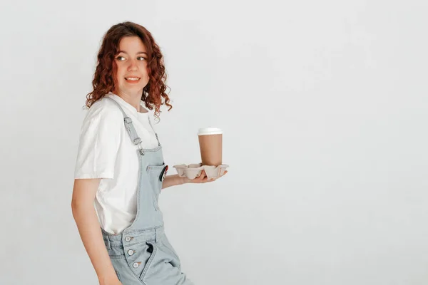 Young Woman Overalls Holding Hot Cup Coffee White Wall Favorite — Stock Photo, Image