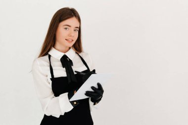 Pahalı bir restoranda siyah önlüklü garson müşterinin siparişini alıyor. Öğle yemeği vakti.