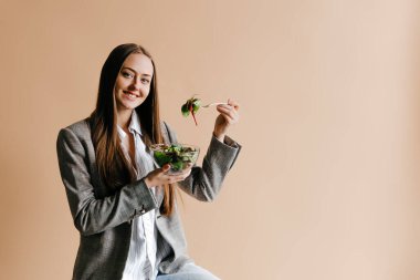 Üniversitede öğle arasında salata yiyen bir öğrenci. Öğle yemeği kavramı ve sağlıklı yiyecekler.