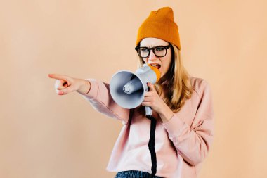 Turuncu şapkalı kız korna çalarken aktörlerle iletişim kuruyor. Genç bayan çalışırken ciddi görünüyor.