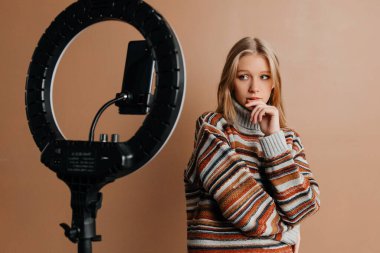 Sarışın kız moda blogu için ders veriyor. Kız yeni içerik yaratıyor.