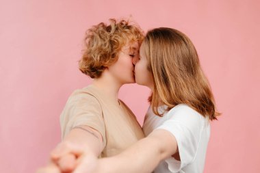 Mutlu lezbiyen çift dans ediyor, eğleniyor pembe arka planda poz veriyor, aşklarını kutluyorlar.