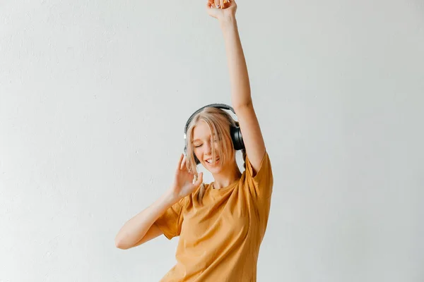 Radosna Młoda Kobieta Słuchająca Muzyki Słuchawkach Żółtej Koszulce Białym Tle — Zdjęcie stockowe