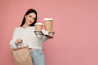 Pembe arka planda poz veren bir kızın portresi. Kız gülümsüyor ve doğrudan kameraya bakıyor.