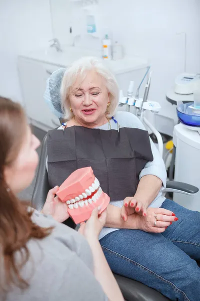 Pionowe Ujęcie Starszej Kobiety Siedzącej Krześle Dentystycznym Klinice Rozmawiającej Lekarzem — Zdjęcie stockowe