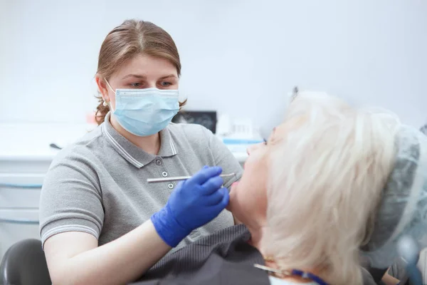 Dentystka Masce Medycznej Badająca Zęby Starszego Pacjenta — Zdjęcie stockowe