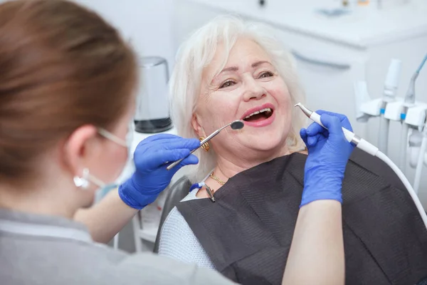 Happy Senior Kobieta Coraz Leczenie Stomatologiczne Przez Profesjonalnego Dentysty — Zdjęcie stockowe
