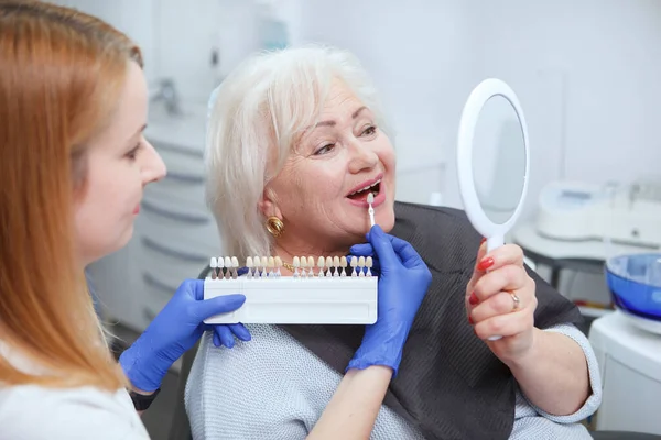 Dentista Feminino Ajudando Seu Paciente Sênior Escolher Dentes Branqueamento Sombra — Fotografia de Stock