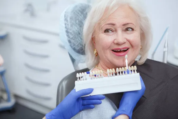 Nierozpoznawalny Dentysta Wybierający Odcień Wybielania Zębów Dla Starszego Pacjenta Przestrzeń — Zdjęcie stockowe