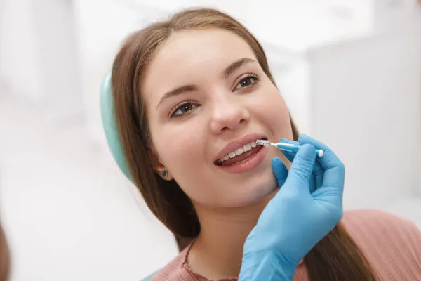 Zbliżenie Pięknej Kobiety Leczonej Stomatologicznie Przez Dentystę Przy Użyciu Szczoteczki — Zdjęcie stockowe