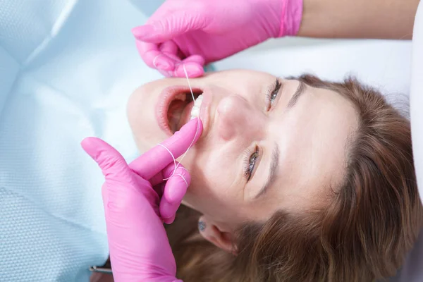 Nierozpoznawalny Dentysta Nici Dentystycznej Zębów Pacjentki — Zdjęcie stockowe