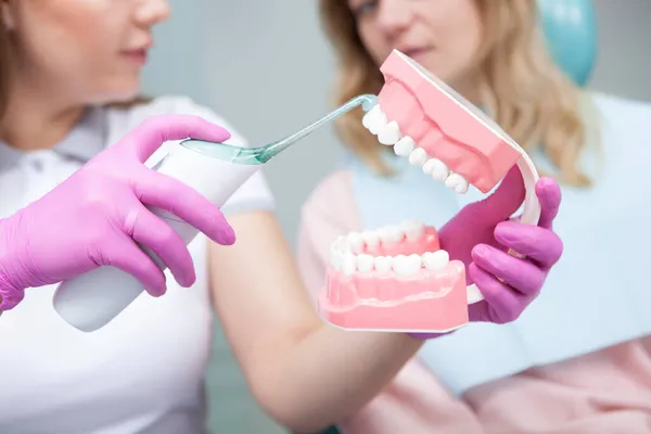 Dentystka Kształci Swojego Pacjenta Pokazuje Jak Czyścić Zęby Ultradźwiękową Szczoteczką — Zdjęcie stockowe