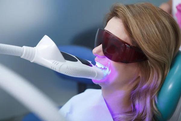 Zbliżenie Dojrzałej Kobiety Wybielającej Zęby Gabinecie Dentystycznym Okularach Ochronnych — Zdjęcie stockowe