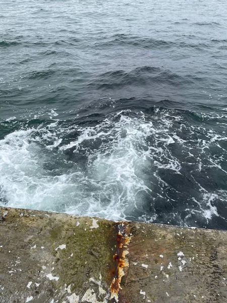 海浪冲刷在海上混凝土桥墩上的垂直镜头 — 图库照片