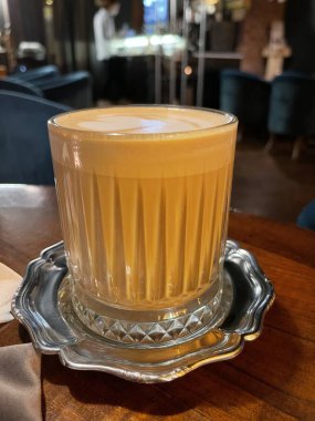 Dikey olarak, gümüş bardak tutacağında lezzetli latte.