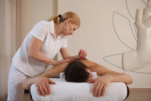 Elderly Professional Female Masseur Working Spa Center Massaging Back Man — Stock Photo, Image