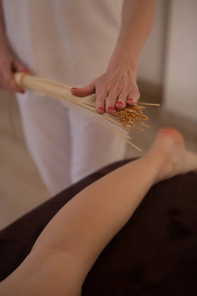 Vertical Shot Masseur Using Bamboo Massage Broom Legs Female Client — Stockfoto