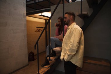 Genç çift akşamları otel odalarında televizyon seyrediyor.