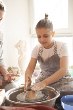 Çömlekçi çarkına esrar atan bir çocuğun dikey çekimi.