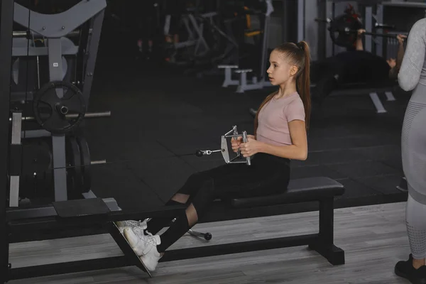 Teenage Girl Exercising Rowing Gym Machine Copy Space — Stok fotoğraf